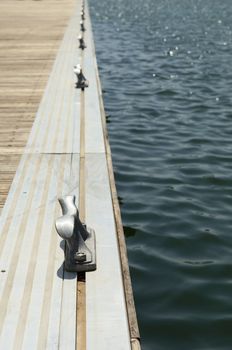 Detail of a wooden floating dock with mooring bitts