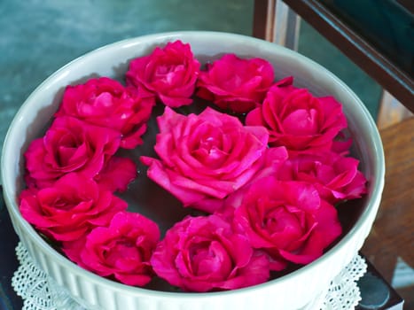 Pink Chulalongkorn roses floating in ceramic bowl