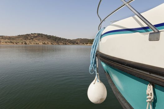 Detail of a blue and white boat prow with hanging fender