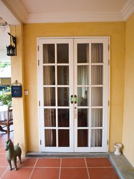 Double patio white french doors with windows on yellow wall