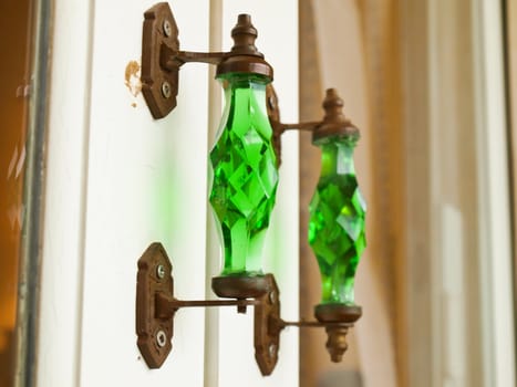 A green glass vintage door handle on glass door.