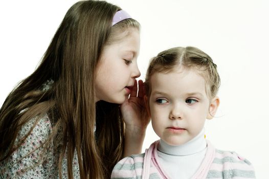 An image of a girl telling a secret to her sister