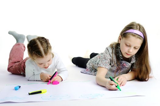 An image of two little sisters drawing together