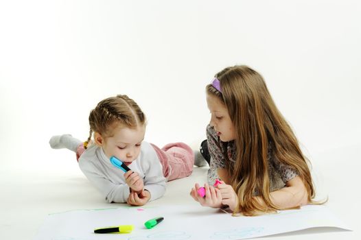 An image of two little sisters drawing together