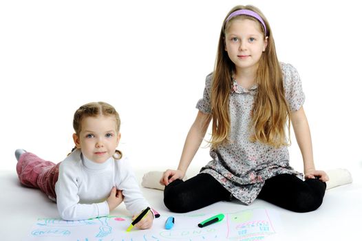 An image of two little sisters drawing together