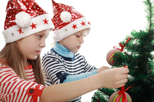 Two little girls decorating a new year tree