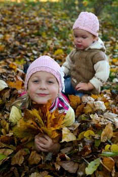 An image of children keeping yellow maple leaves