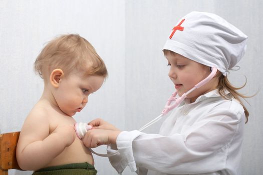 A girl and a little baby playing a doctor