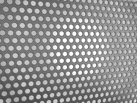 Carbon fibre surface with holes over studio light background