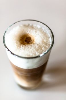Coffee latte in a tall glass on white background shallow depth of field