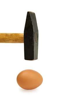 Hammer approaching delicate egg shell. Image is isolated on white.