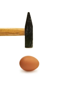 Hammer approaching delicate egg shell. Image is isolated on white.