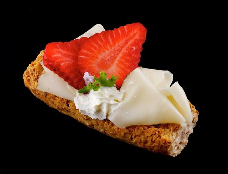 CreaspBread sandwich with cheese and strawberry isolated on black background