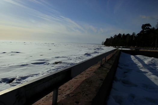 beautiful winter landscape with a parapet, trees and snow