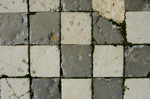 Background of white brick tiled old pavement with moss on it.