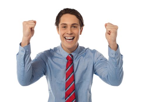 Portrait of confident young businessman celebrating success with arms up