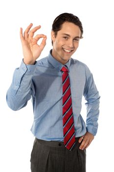 Male executive gesturing great ok sign, smiling at camera