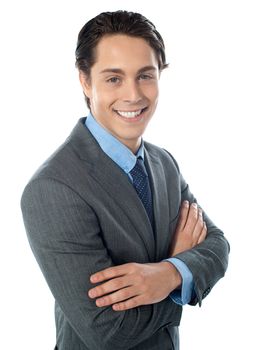 Young successful businessman posing with folded arms over white background