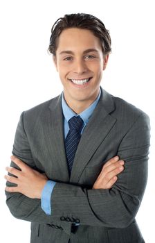 Handsome young man in business suit posing with folded arms