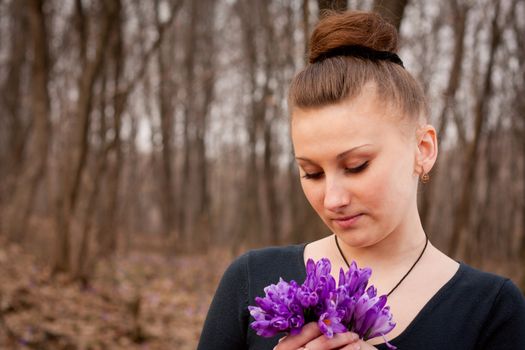 beautiful girl with snowdrops in a forest