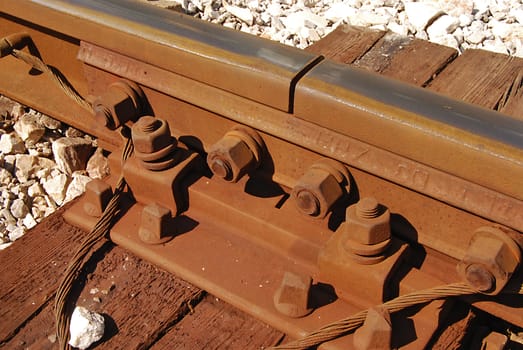 Rusty steel rail connection, wooden cross-tie, bolts, nuts