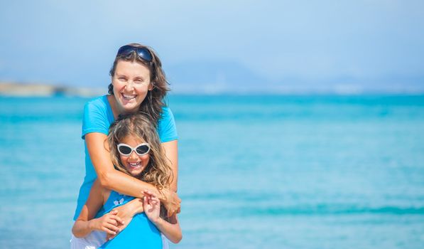 Mother and her daughter having fun on tropical beach