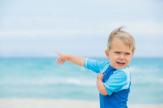 Back view cute 2 years old boy runing on tropical beach