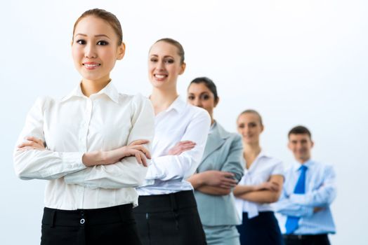 group of business people standing in a row, smiling and crossing his arms