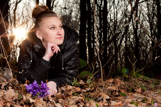 beautiful girl with snowdrops in a forest