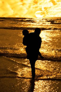 two girls in silhouette against a golden sunset one holding up the over with affection