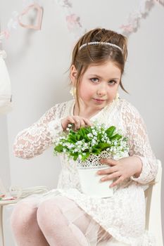 a beautiful little girl with flowers in a pot