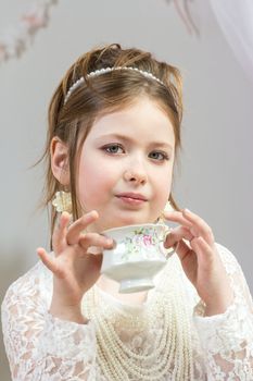 A beautiful little girl having a tea party