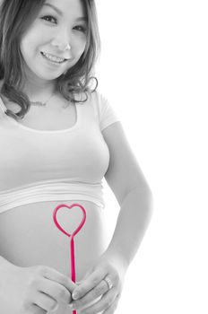 Pregnant woman holding red heart to the abdomen