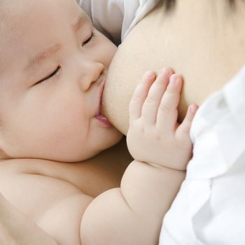 Asian mother breast feeding her infant