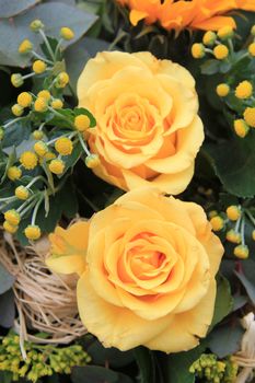 some big yellow roses in close up, part of a bouquet