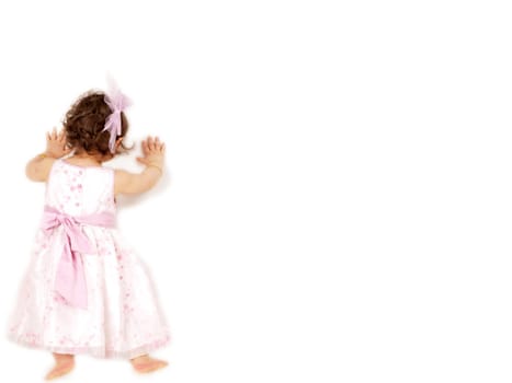 Little girl in a beautiful dress, leaning towards  great white wall