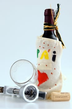 Wine bottle with corkscrew, a cork and a cup tumbled