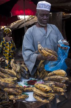 Shopkeeper selling plantain at the local market in Bamako, Mali