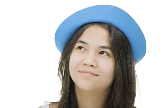 Beautiful young teen girl in blue hat, looking up with thoughtful expression.Isolated on white