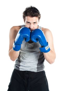 A young boxer in gray shirt and blue boxing gloves
