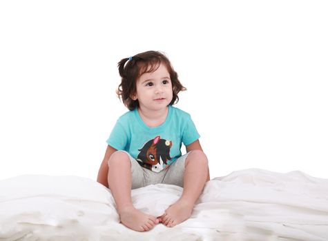 Curly toddler girl in bed, looking into camera