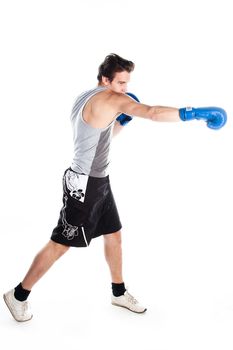 A young boxer in gray shirt and blue boxing gloves