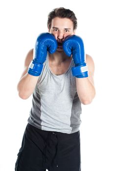 A young boxer in gray shirt and blue boxing gloves