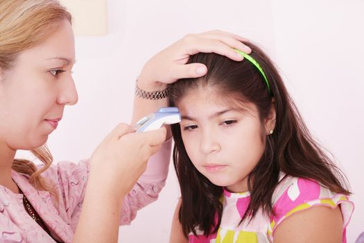 Portrait of a sick child being checked with a thermometer by a doctor