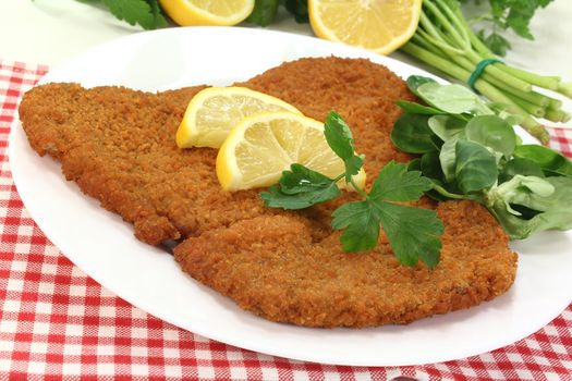 freshly roasted wiener schnitzel with lemon slices and parsley