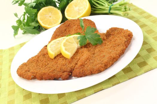 fried Wiener Schnitzel with lemon slices and parsley on a napkin