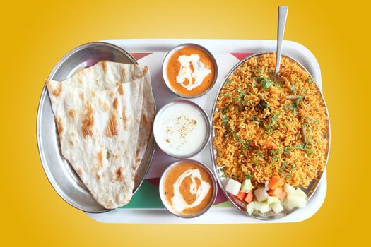Indian biryani, butter naan with spicy curry and raitha on a plate with clipping mask