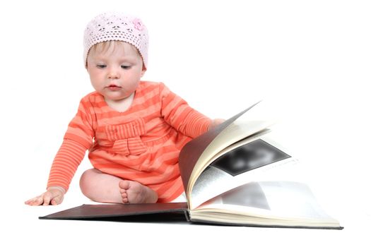 The little blue-eyed girl thumbs through the book. A portrait on a white background. Option 8