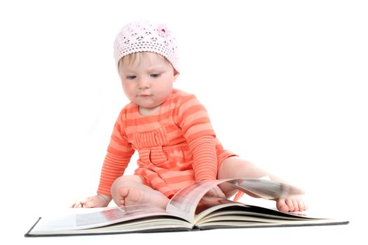 The little blue-eyed girl thumbs through the book. A portrait on a white background. Option 2.