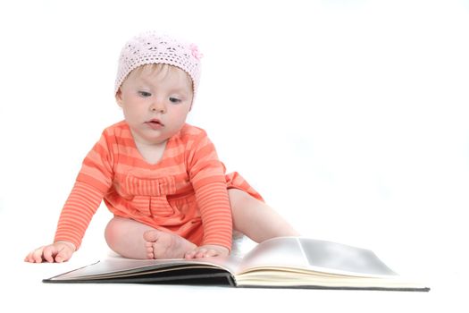 The little blue-eyed girl thumbs through the book. A portrait on a white background. Option 7